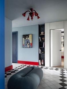 a living room with a black and white checkered floor, blue walls and a painting on the wall