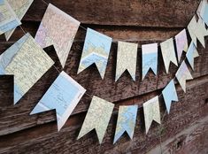 a map bunting is hanging on the side of a wooden building with paper flags