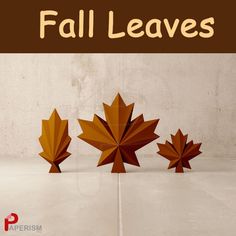 three wooden maple leaf sculptures sitting on top of a white floor