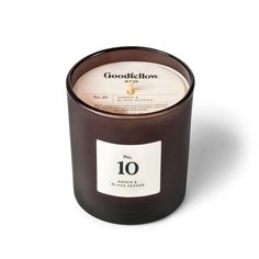 a candle that is brown and white with the word good glow on it's label