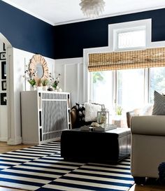 a living room with blue and white walls, striped rugs and furniture in it