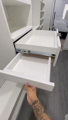 a man is opening the drawers in his kitchen cabinet to show what's inside