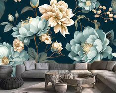 a living room with blue and white flowers on the wall next to a gray couch