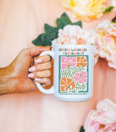 a woman is holding a coffee mug with flowers on it and the words special language at the bottom