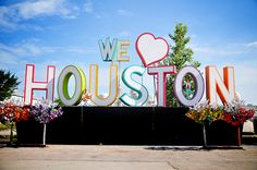 we love houston sign surrounded by flowers and trees