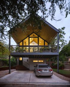 a car is parked in front of a house with a covered porch and attached garage