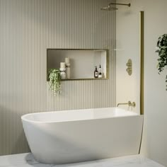 a white bath tub sitting in a bathroom next to a mirror and potted plant