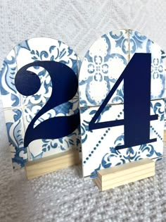 two blue and white wooden numbers sitting on top of each other, with one number in the middle