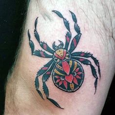 a black and red spider tattoo on the leg