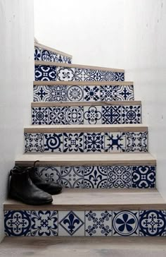 a pair of shoes sitting on the steps in front of blue and white tiled stairs