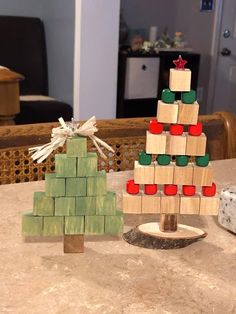 a small wooden christmas tree sitting on top of a table next to a pile of blocks