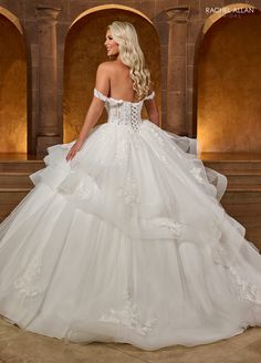 a woman in a white wedding dress is posing for the camera with her back to the camera