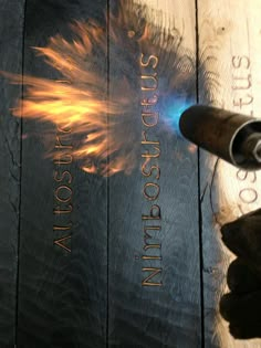 a close up of a book on a wooden surface with fire coming out of it