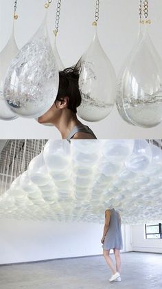 a woman is standing in an empty room with bubbles hanging from it's ceiling