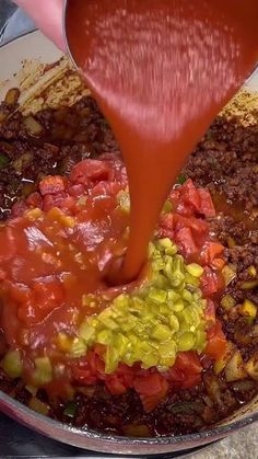 the sauce is being poured over the food in the pan