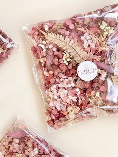 three bags filled with dried flowers on top of a table