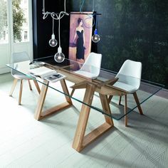 a glass table with two white chairs and a painting on the wall