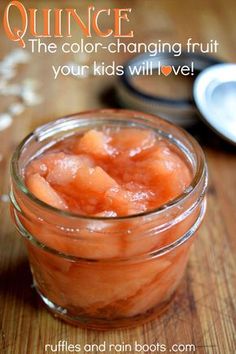 a jar filled with fruit sitting on top of a wooden table