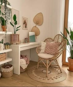 a room filled with lots of plants next to a white desk and shelves on the wall