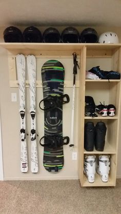 a snowboard sitting on top of a wooden shelf next to skis and boots