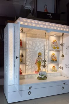 a white display case filled with lots of figurines and lights on top of it