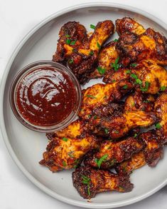 chicken wings on a plate with ketchup and dipping sauce