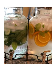 two glass jars filled with water and orange slices