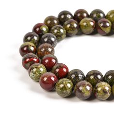 a bracelet made out of red and green glass beads on a white background with space for text