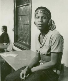 a black and white photo of a woman sitting at a desk in front of a window