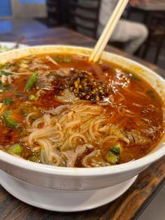 a bowl of soup with chopsticks in it