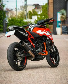 an orange and black motorcycle parked on the street