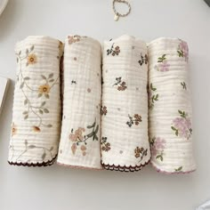 four baby swaddles are lined up on a table