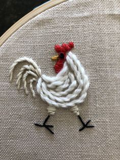 a close up of a rooster on a piece of fabric