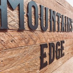 a close up of the letters on a wooden sign that says mountain's edge