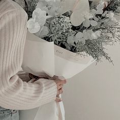 a woman holding a bouquet of flowers in her hands with the words love written on it