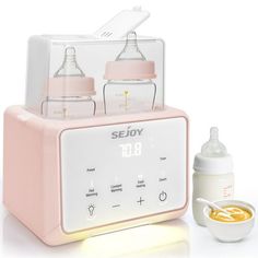 a baby bottle and feeding utensil set up on a white surface with the words sejoy in front of it