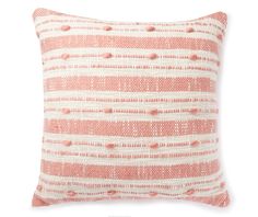 an orange and white pillow with dots on it