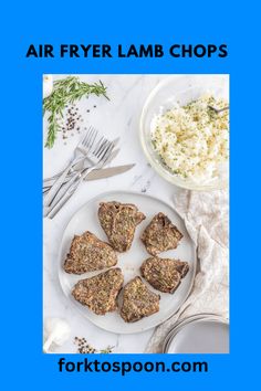 four pieces of lamb chops on a plate next to a bowl of rice and silverware