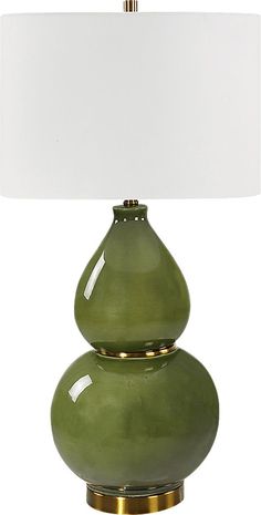 a green lamp sitting on top of a table next to a white lampshade