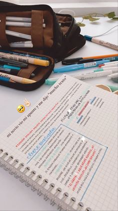 an open notebook sitting on top of a table next to pencils