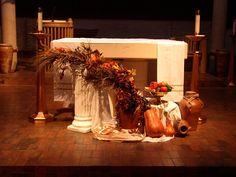 an altar with vases and flowers on the ground in front of it at night