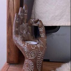 a ceramic hand that is sitting on a shelf next to a window sill and rug