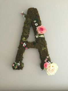 the letters are made out of moss and have flowers on each letter's sides