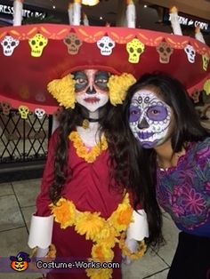 two women with painted faces pose for the camera