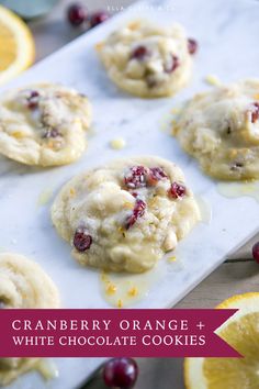 several cookies with cranberries and oranges on a tray