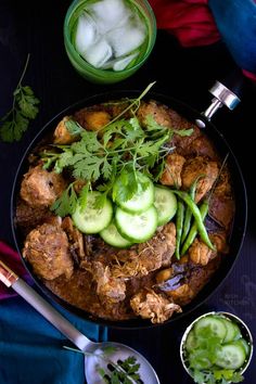 a bowl filled with meat and cucumbers on top of a table