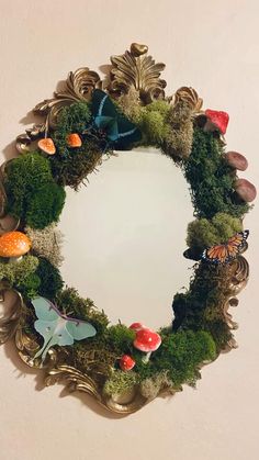 a mirror that has some plants and mushrooms on it in the shape of a wreath