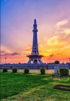 the eiffel tower in paris, france at sunset with green grass and bushes