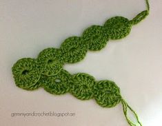 a crocheted piece of green yarn on a white surface