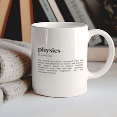 a white coffee mug sitting on top of a table next to a pile of books